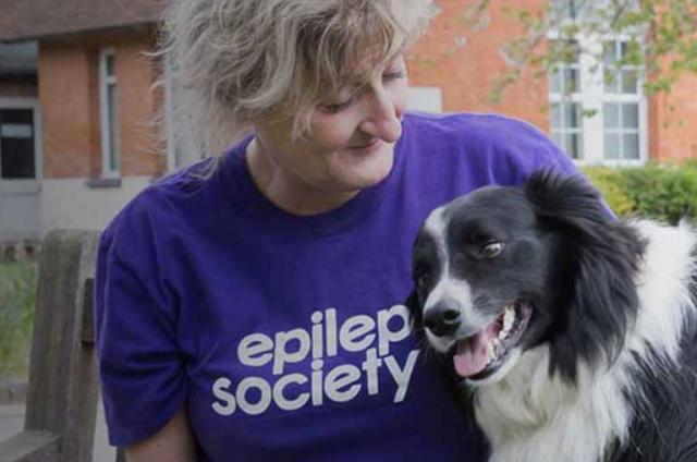 One of our volunteers sitting on a bench with her dog